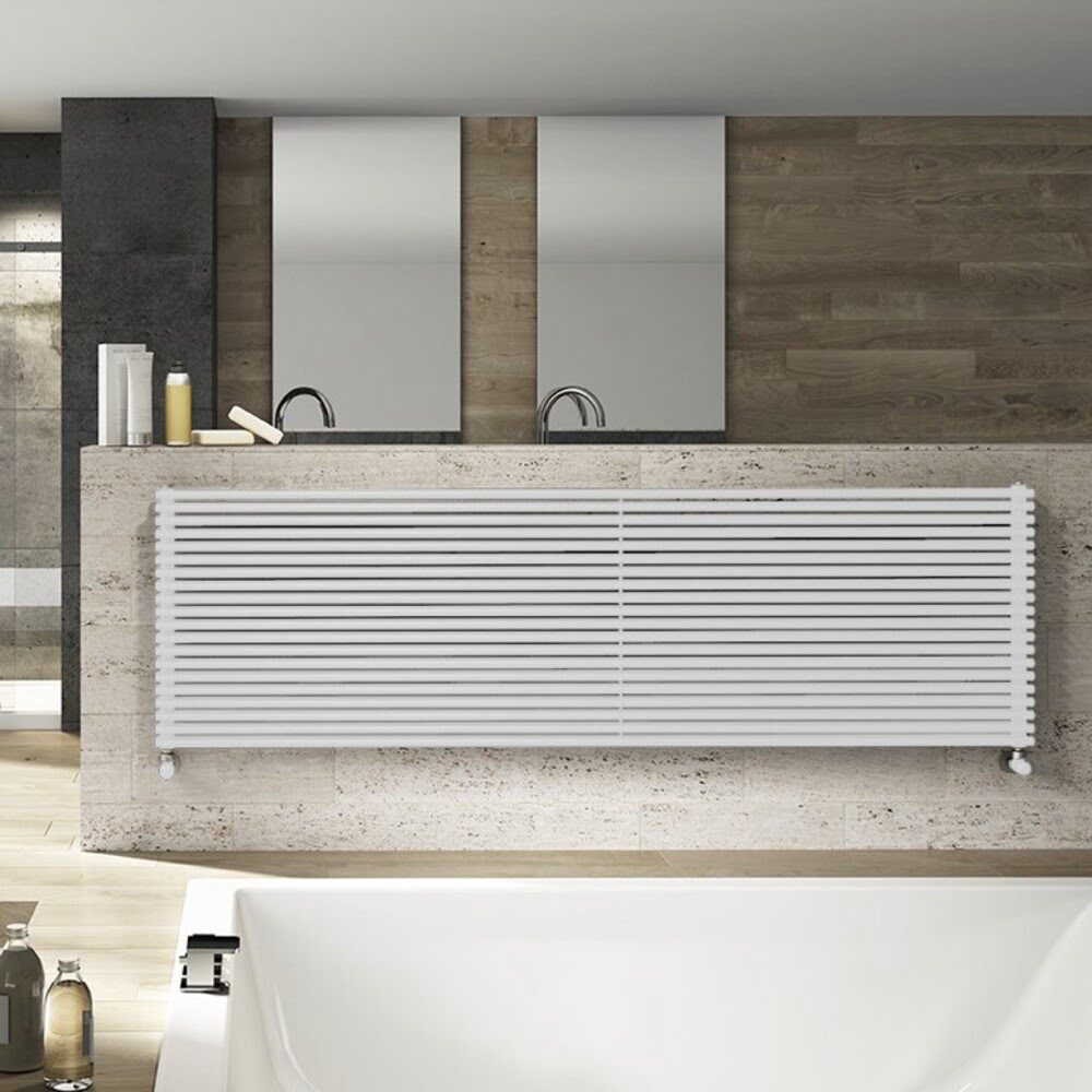 Широкий горизонтальный отопительный радиатор, подсоединенная термоголовка, трубчатый радиатор белого цвета настенный. Батарею можно установить у ванной или душевой, также может служить как полотенцесушитель