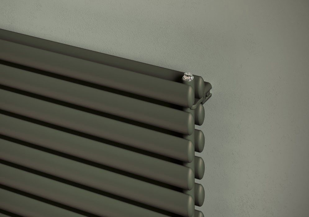 Горизонтальный дизайнерский двойной радиатор 600 мм x 1020 мм имеют стальные овальные трубы и высокую тепловую мощность. Материал – сталь, это хороший проводник тепла и гарантия – 10 лет. Радиатор цвета хаки подвешен на светло зеленой стене